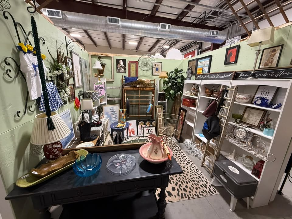 Antiques and vintage booth with a vintage pitcher and basin set, table lamps, and framed art