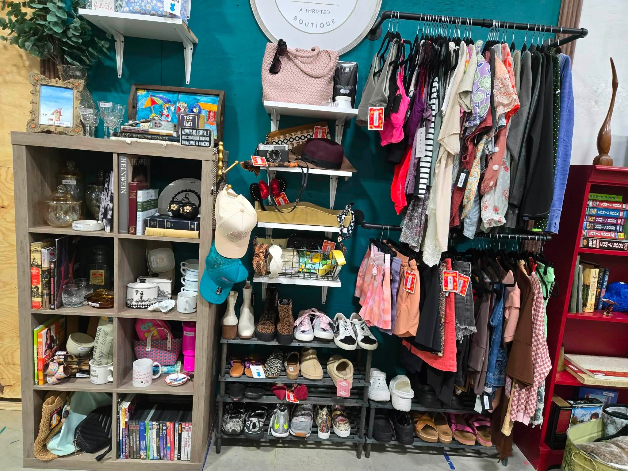 A Thrifted Boutique booth with clothing racks, handbags, hats, and shoes