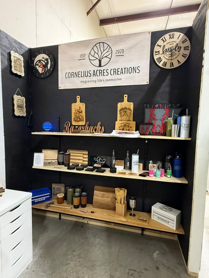 Cornelius Acres Creations handmade booth with laser-engraved cutting boards and personalized wood signs