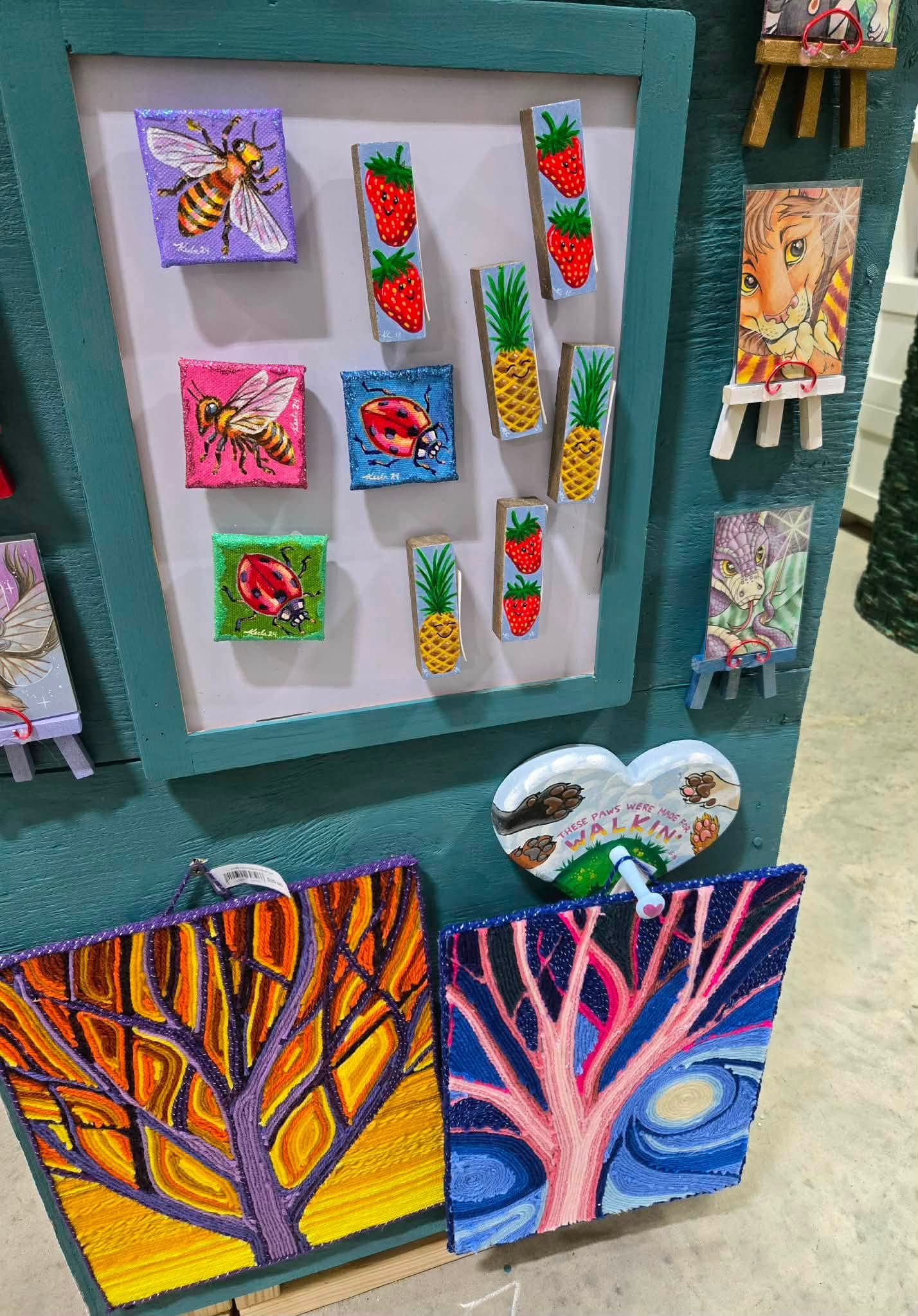 Colorful hand-painted mini canvases of bees, ladybugs, and strawberries
